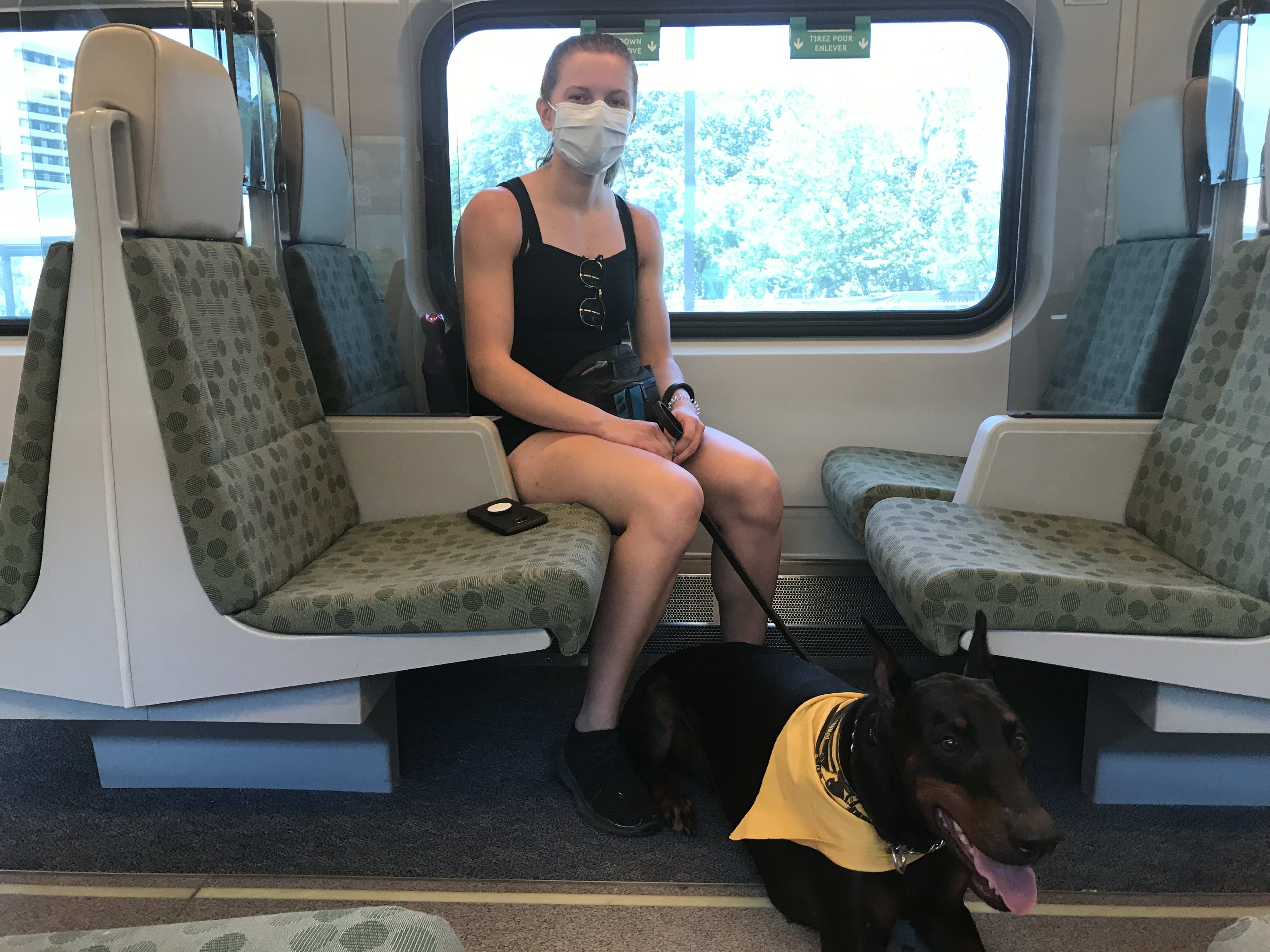 Woman named Olivera Krolj sitting on GO train in a mask, with her dog