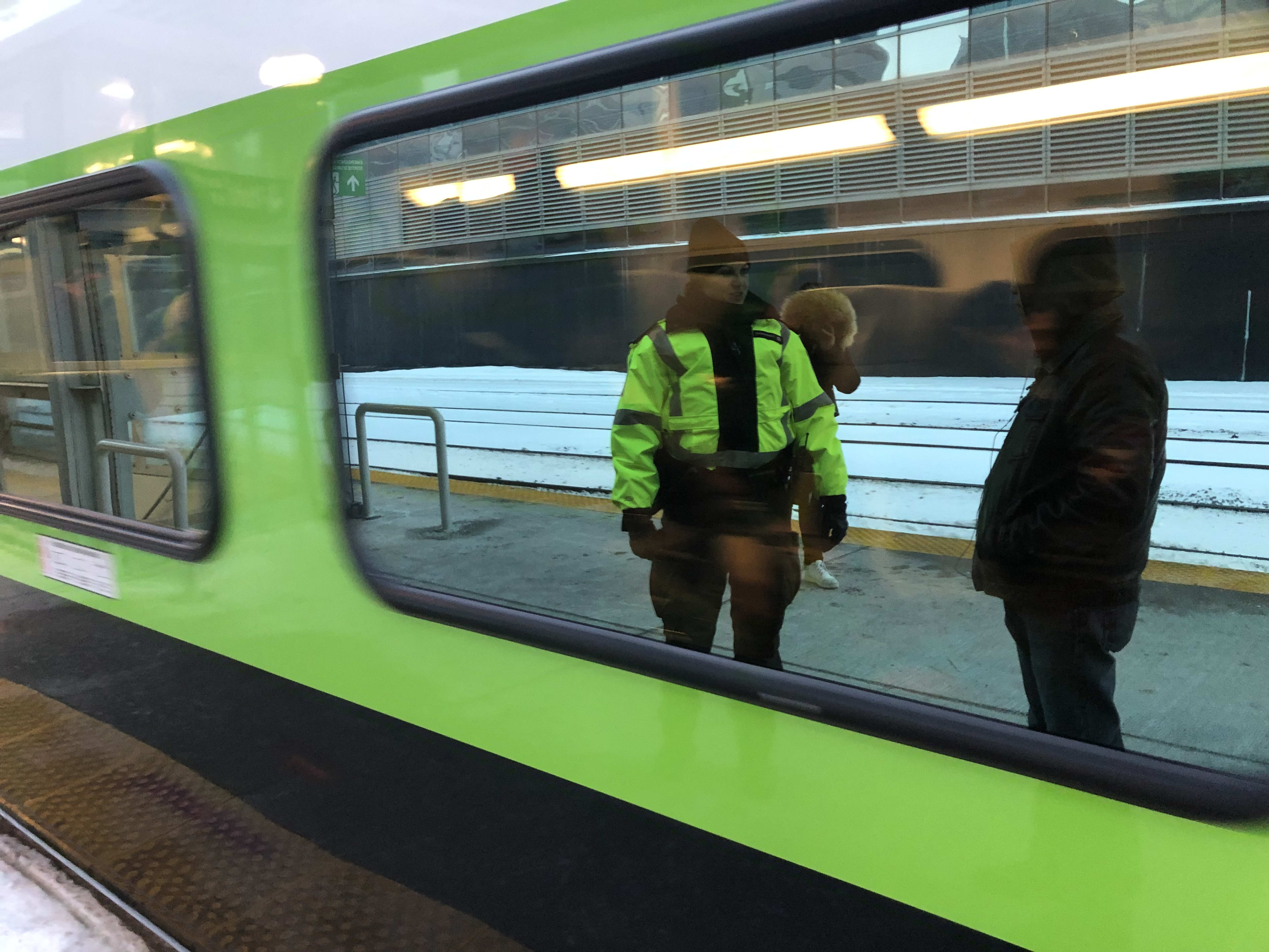 In a reflection of a passing train, Tihana Karanovic, talks to a male passenger as he waits for a...