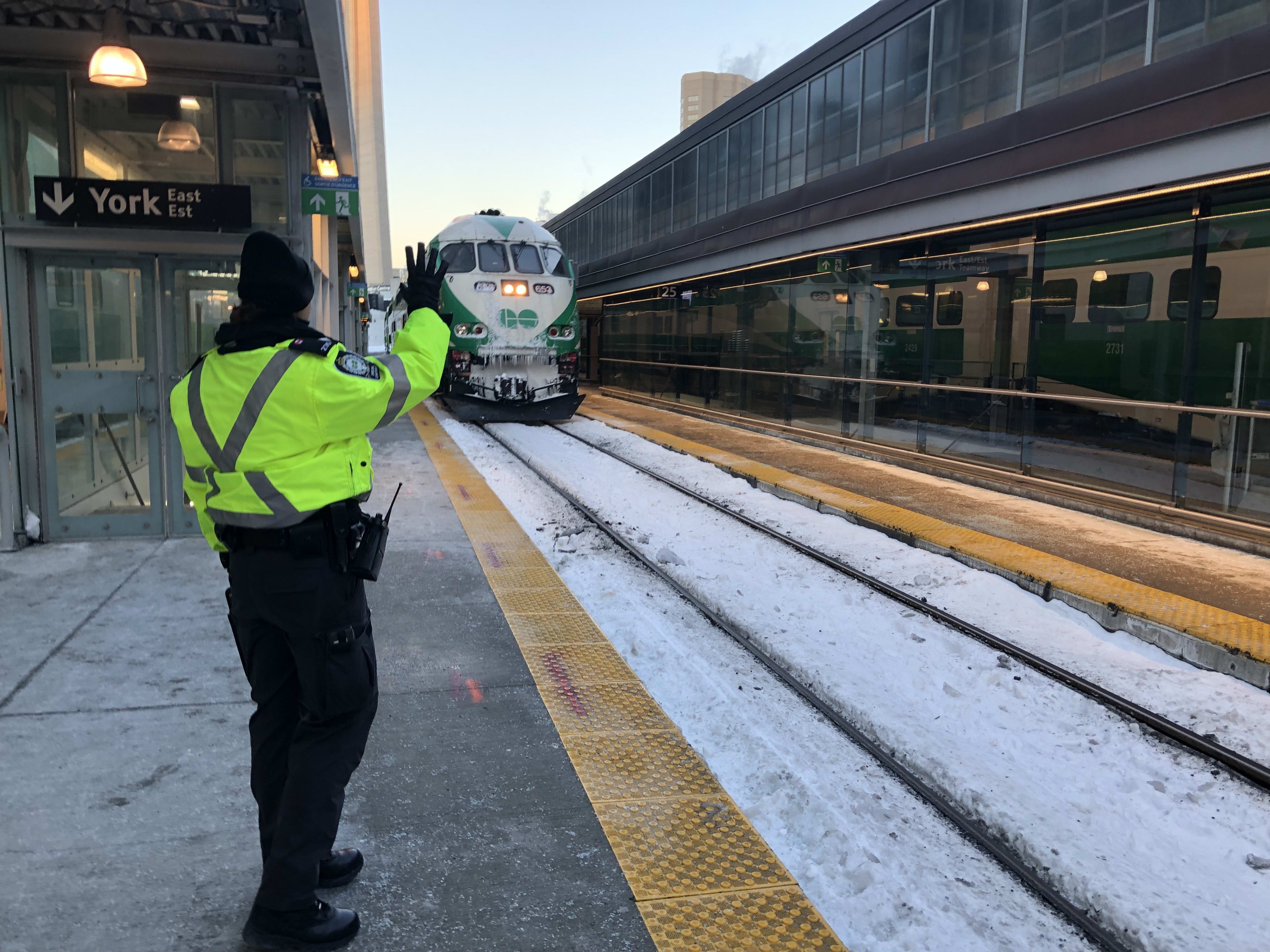 As a train approaches on a cold morning, transit officer Tihana Karanovic waves at the engineer. ...