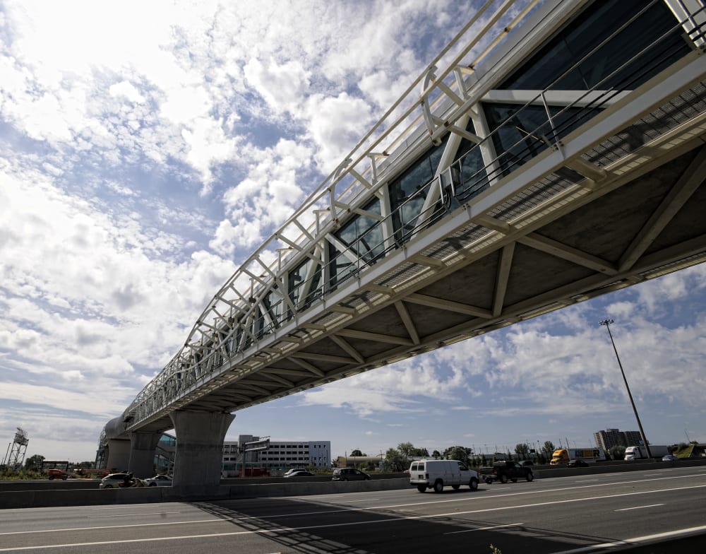 The pedestrian bridge is seen looming over Hwy. 401 traffic during a daylight shot.