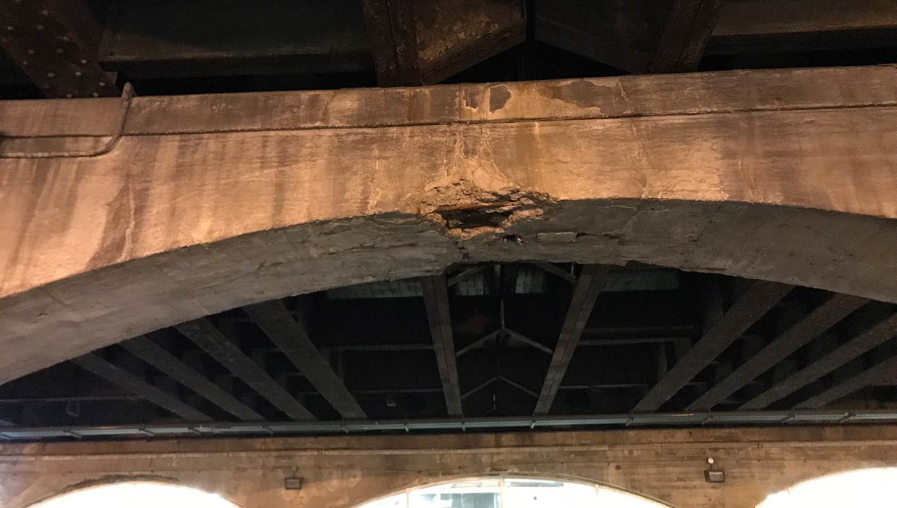Damaged concrete under a bridge-support is shown.
