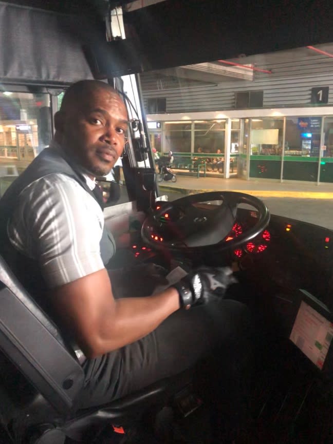 A bus driver sits behind the wheel.