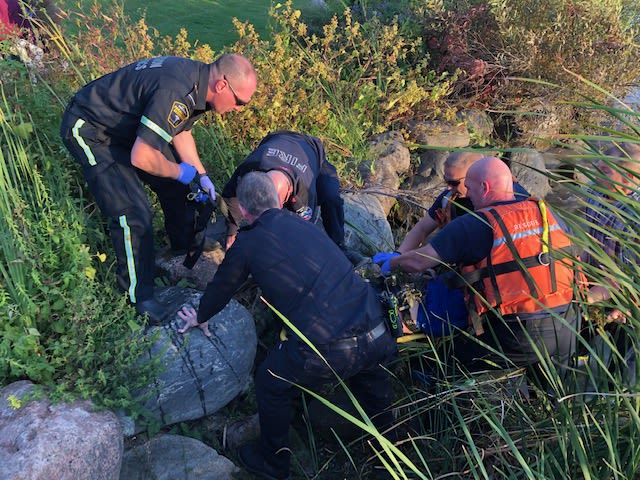 Emergency crews tend to a man by the water's edge.