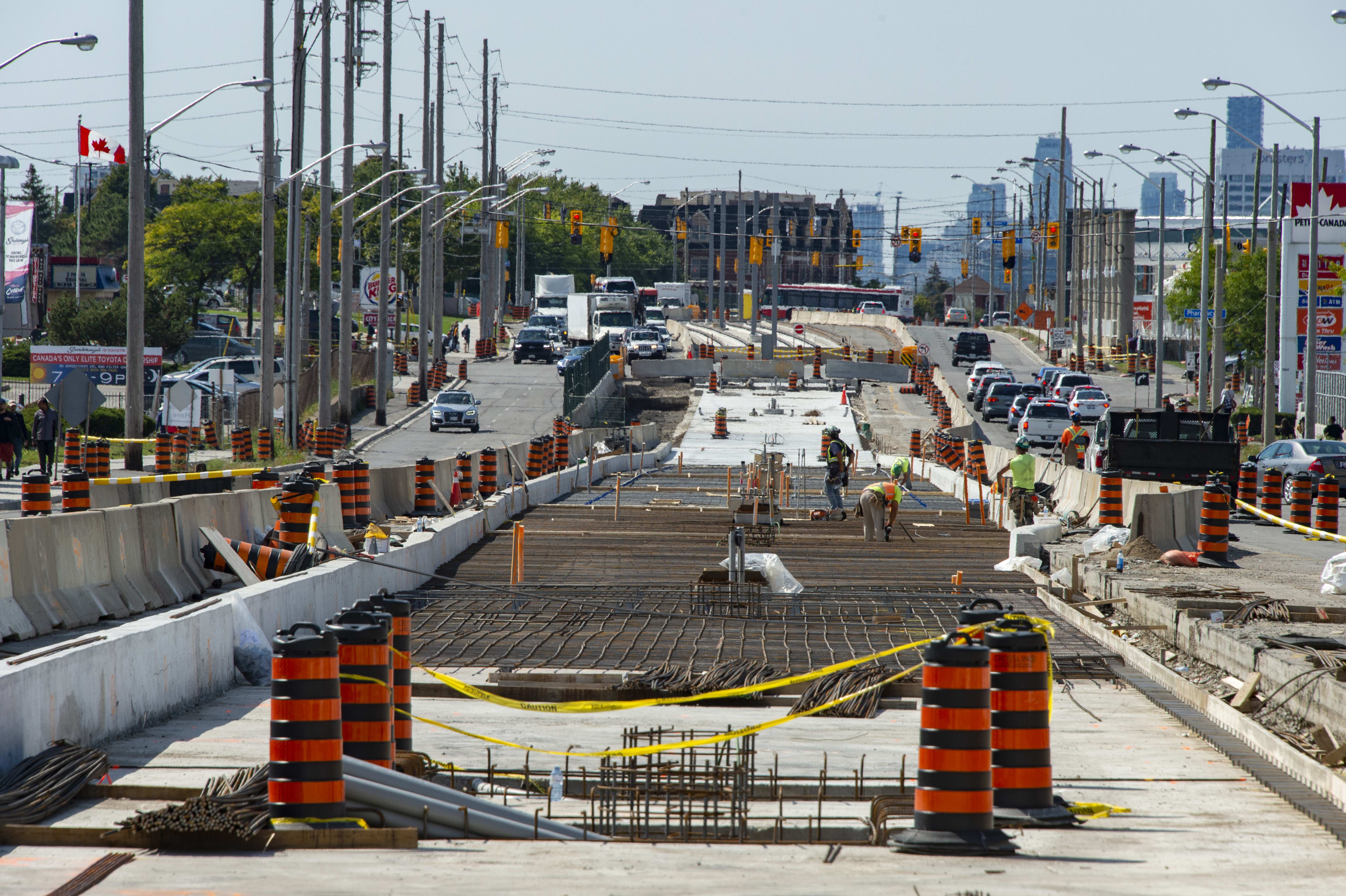 construction at street level on the Eglinton Crosstown LRT tracks and concrete being installed fo...