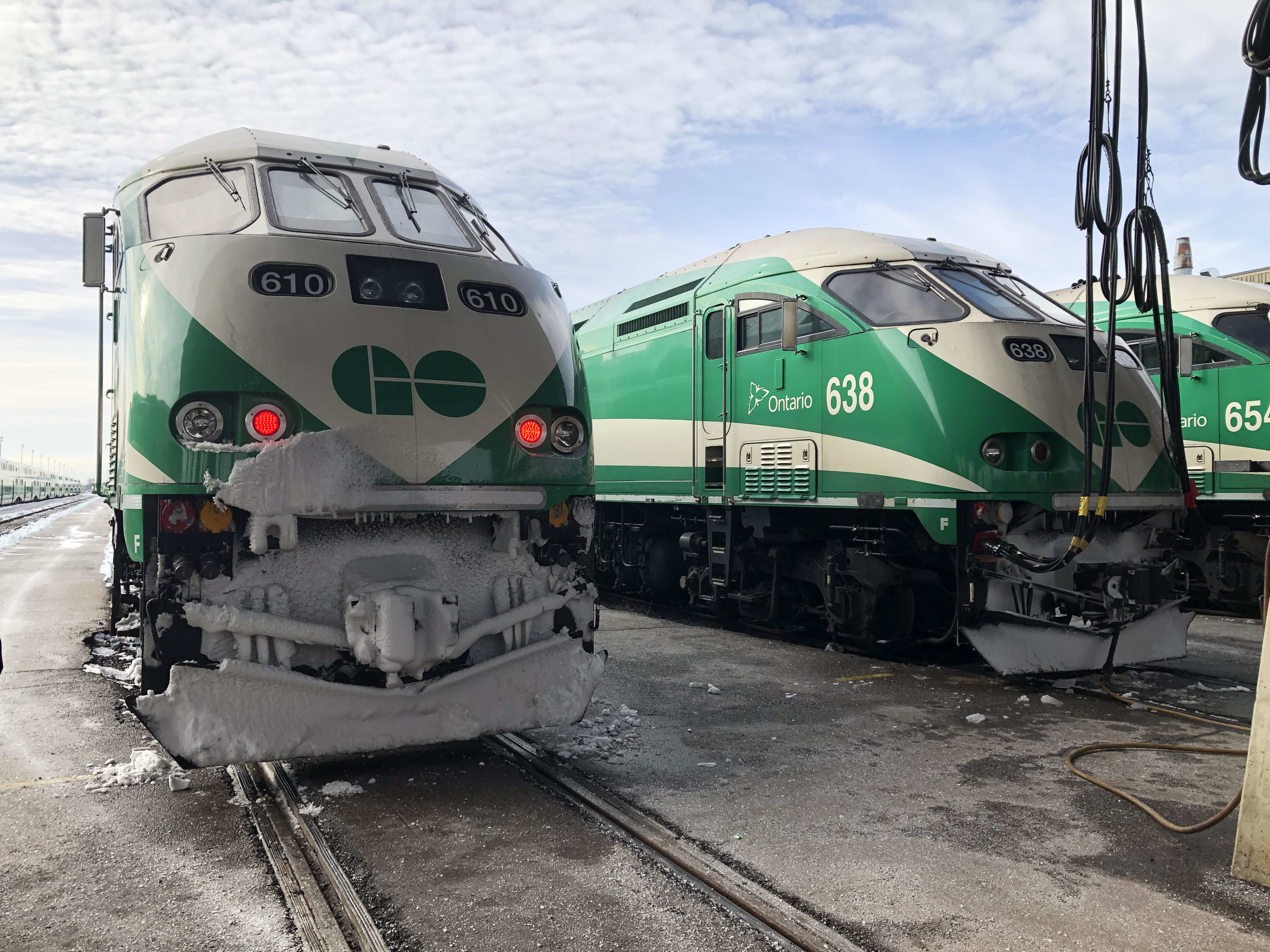 Trains line up, with snow covering their fronts.