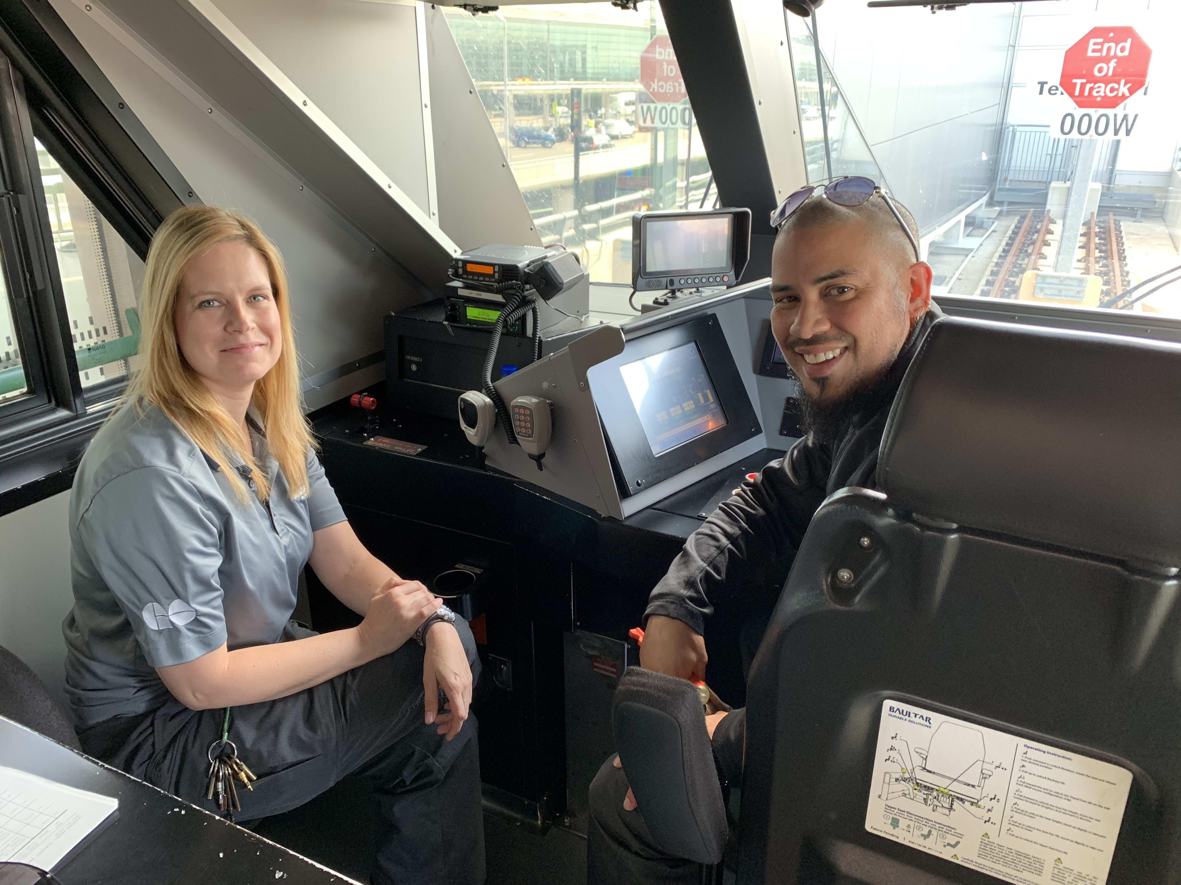 Erica Ling and Jason Simmons pose in the cab of an UP Express train.