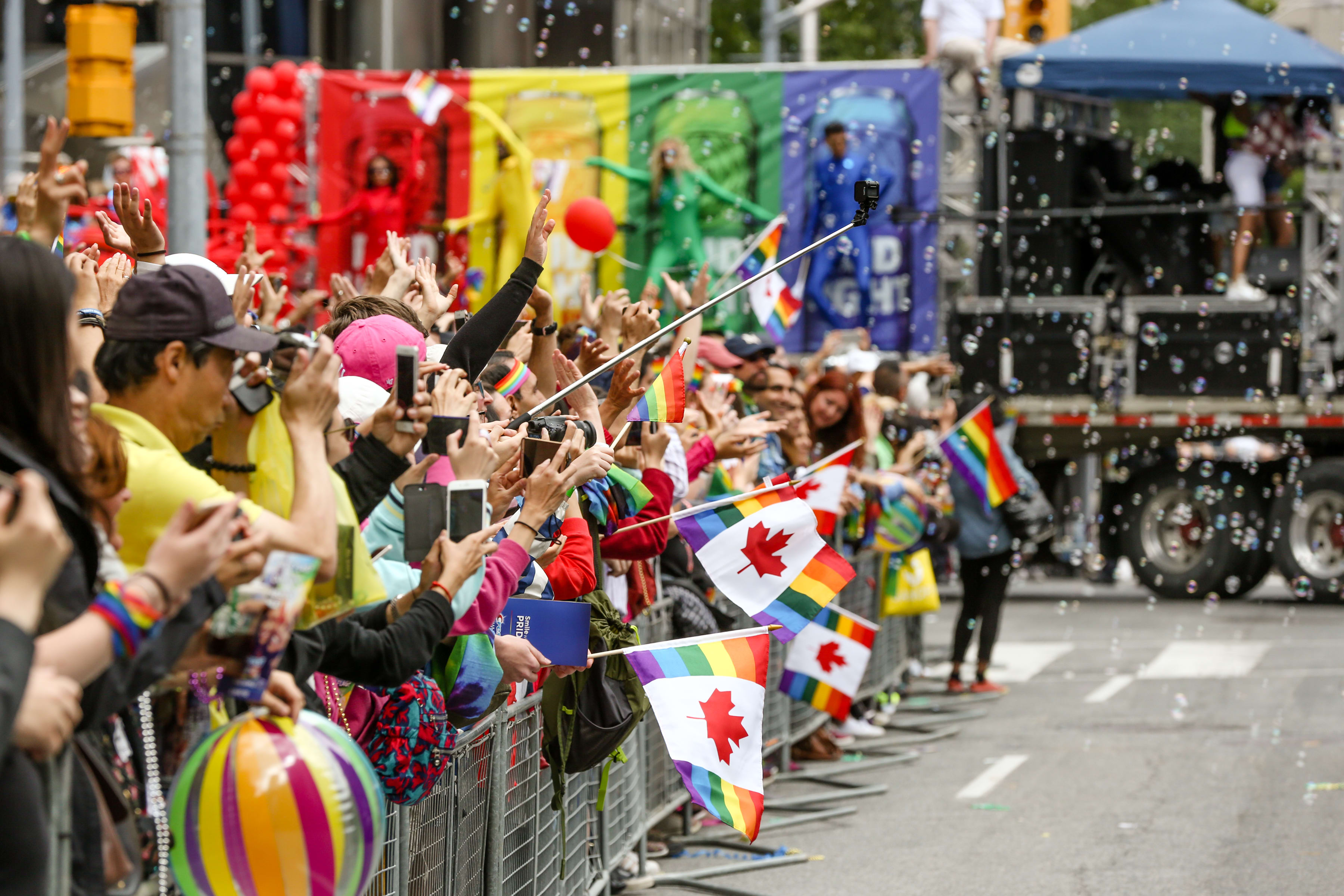 Toronto Pride Parade spectators waving Canada Daye Pride flags