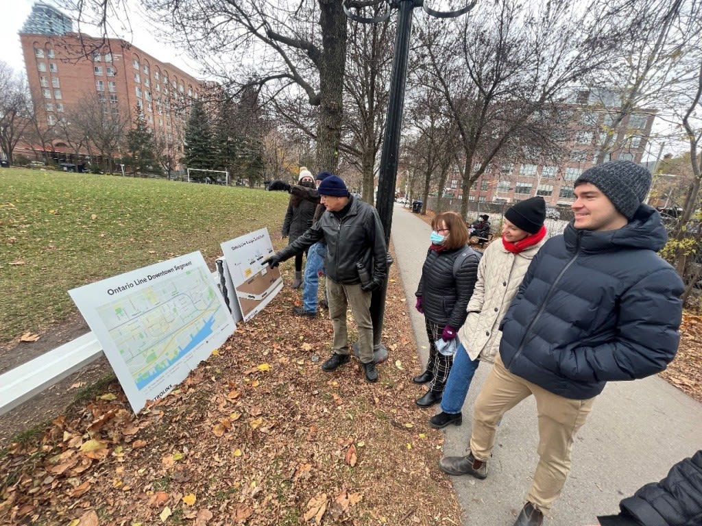 people looking at plans while standing outside.