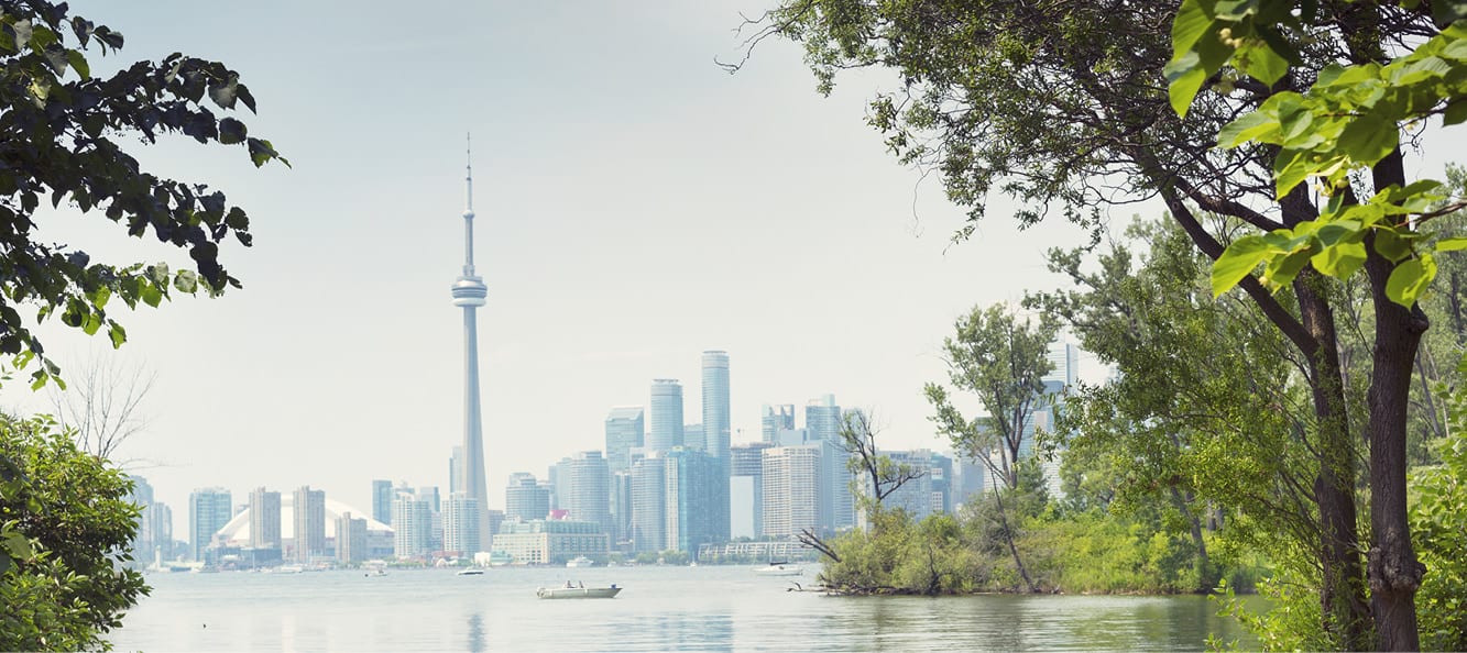 Toronto skyline and lake from Centre Island with trees to the left and right