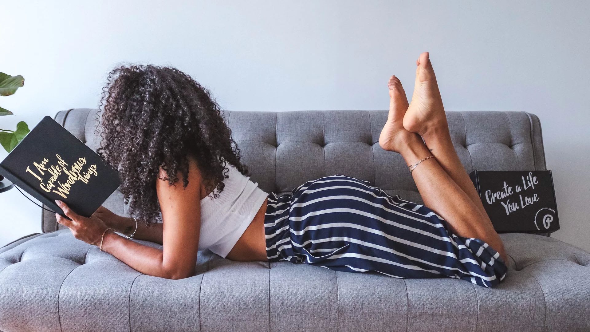 Lady lying on couch with a notebook from PleaseNotes, small owned-black business in Toronto, ON