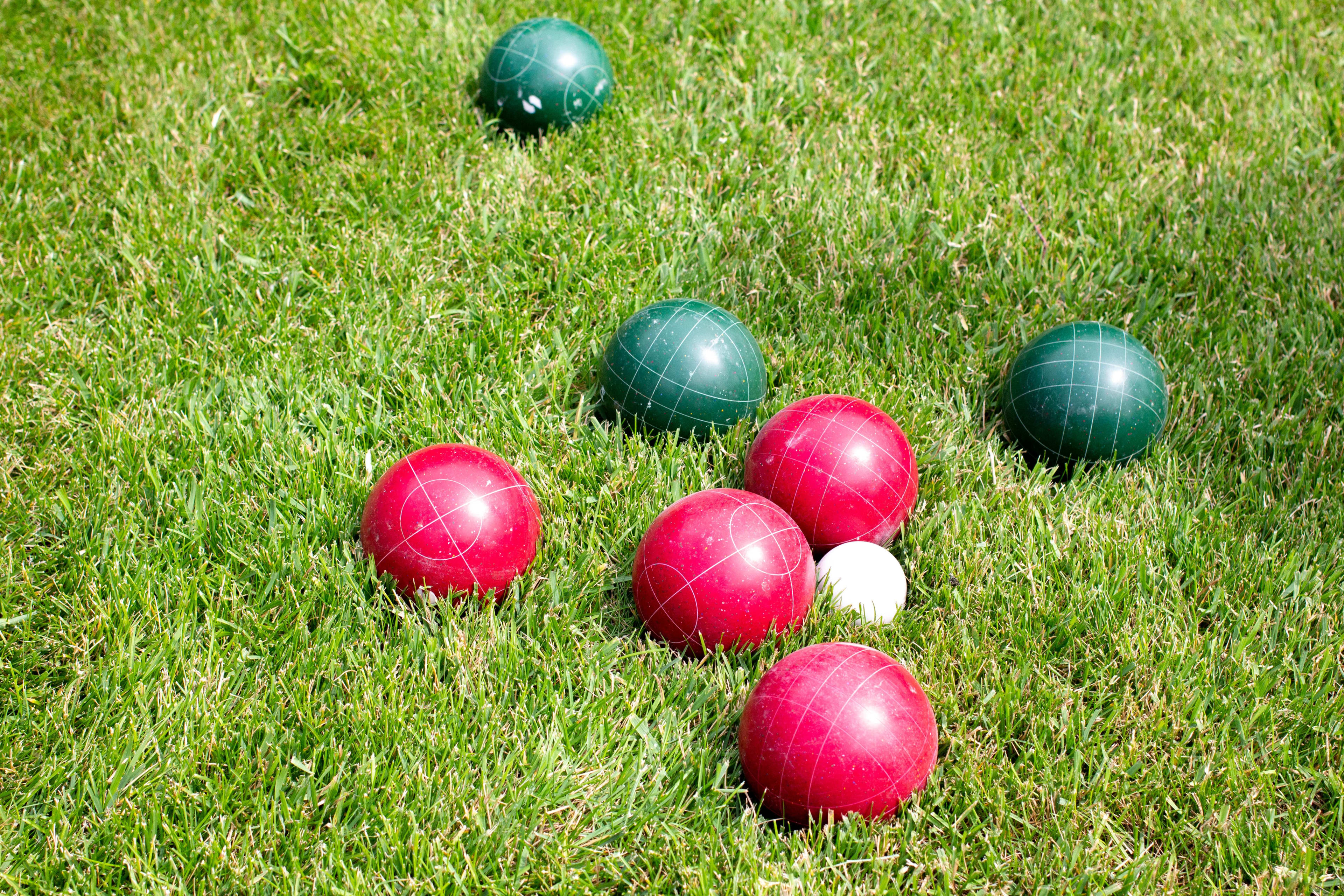 Red and green bocce balls on grass