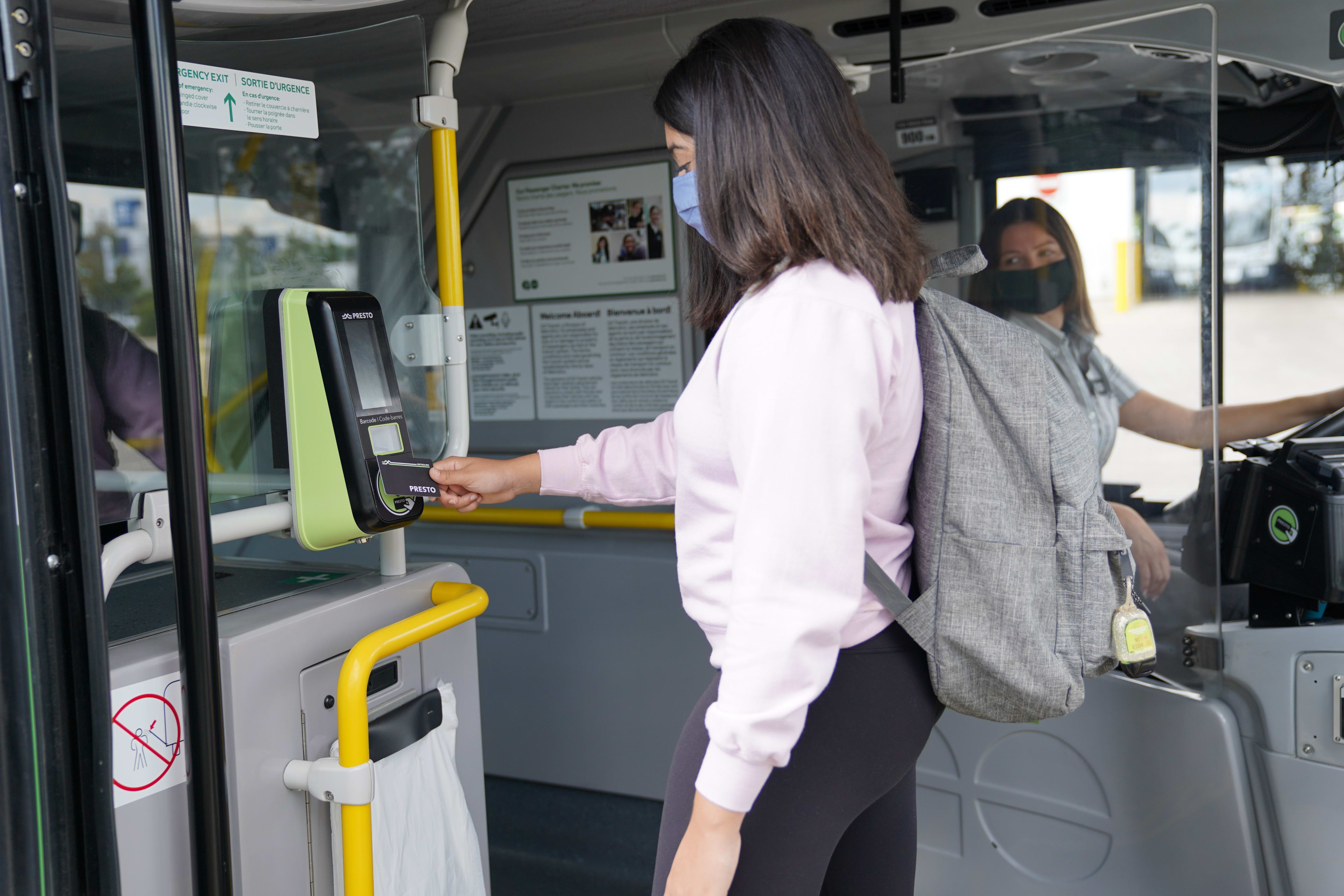 Youth tapping PRESTO card on-board GO Bus