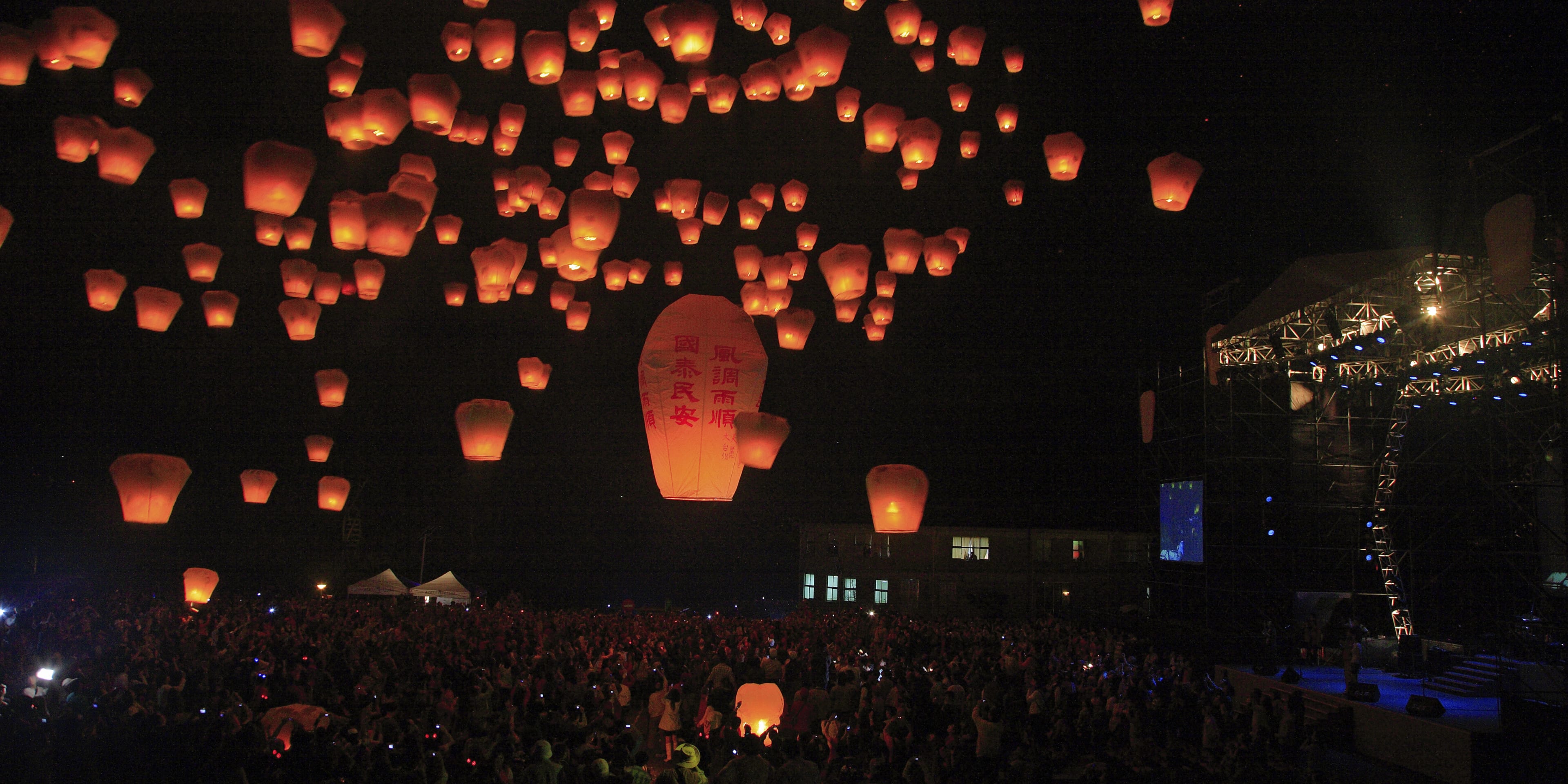 Lanterns flying into the sky at night at the Pingxi Sky Lantern Festival in Taiwan