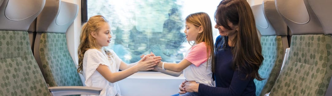A mother and her kids sitting on a GO train