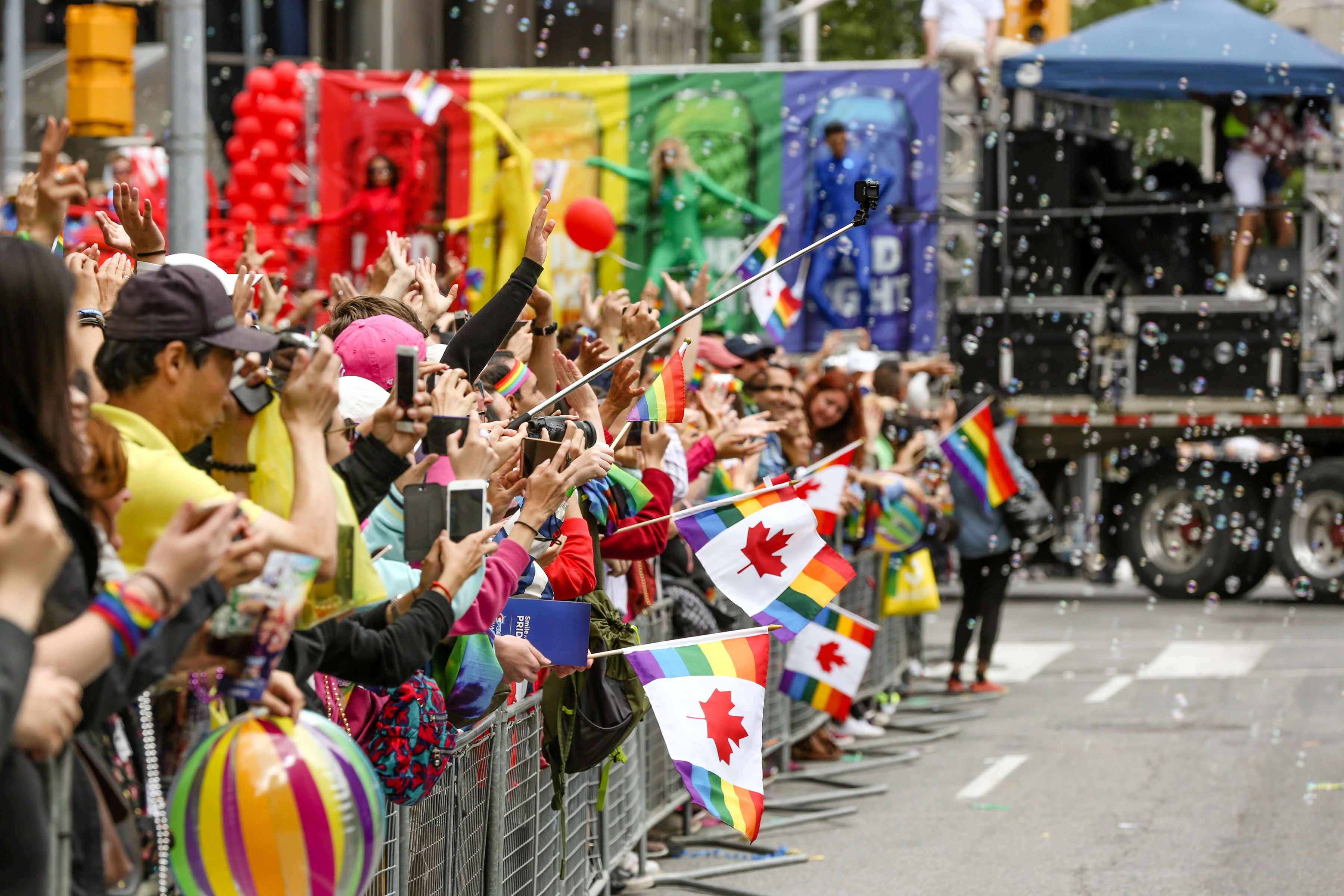 Toronto Pride Parade spectators waving Canada Daye Pride flags