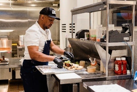 Chef in the kitchen at Friday Burger Company located in the CIBC Square Foodhall in Toronto.