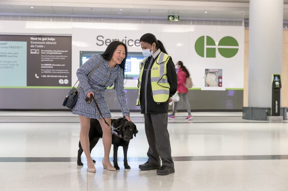 blind woman with guide/service dog and station worker