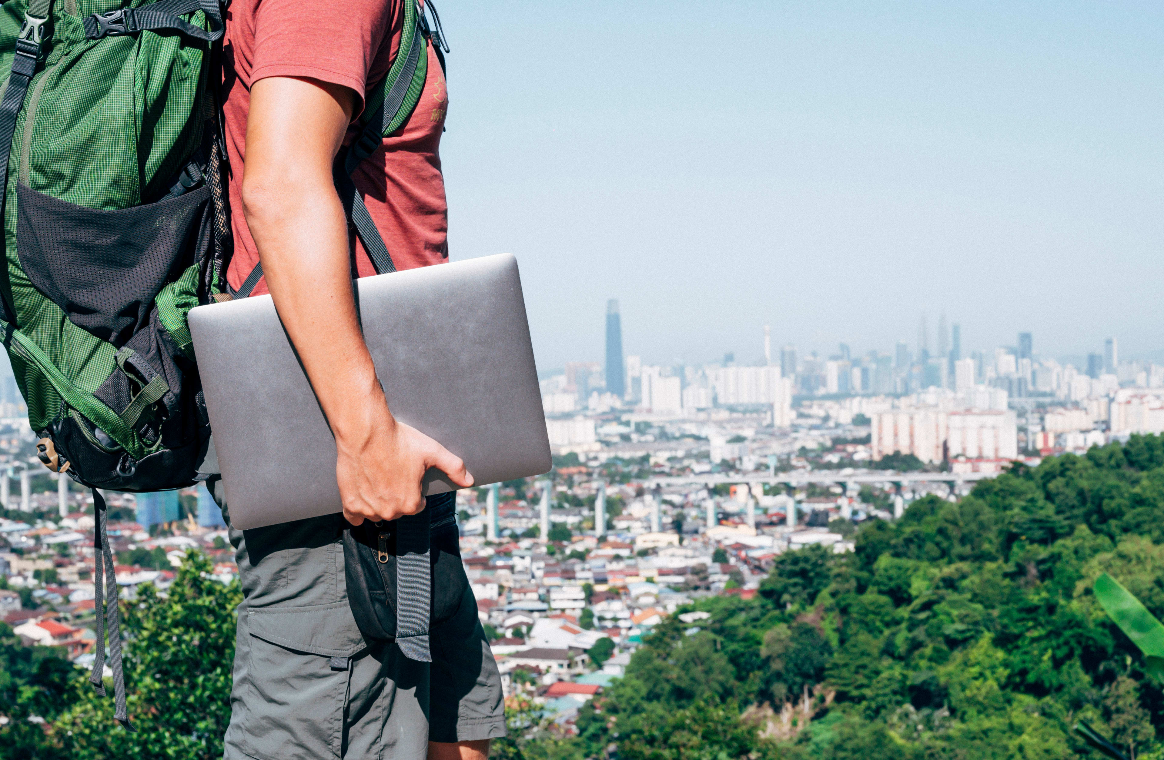 Person standing at the top of a viewpoint with laptop in hand