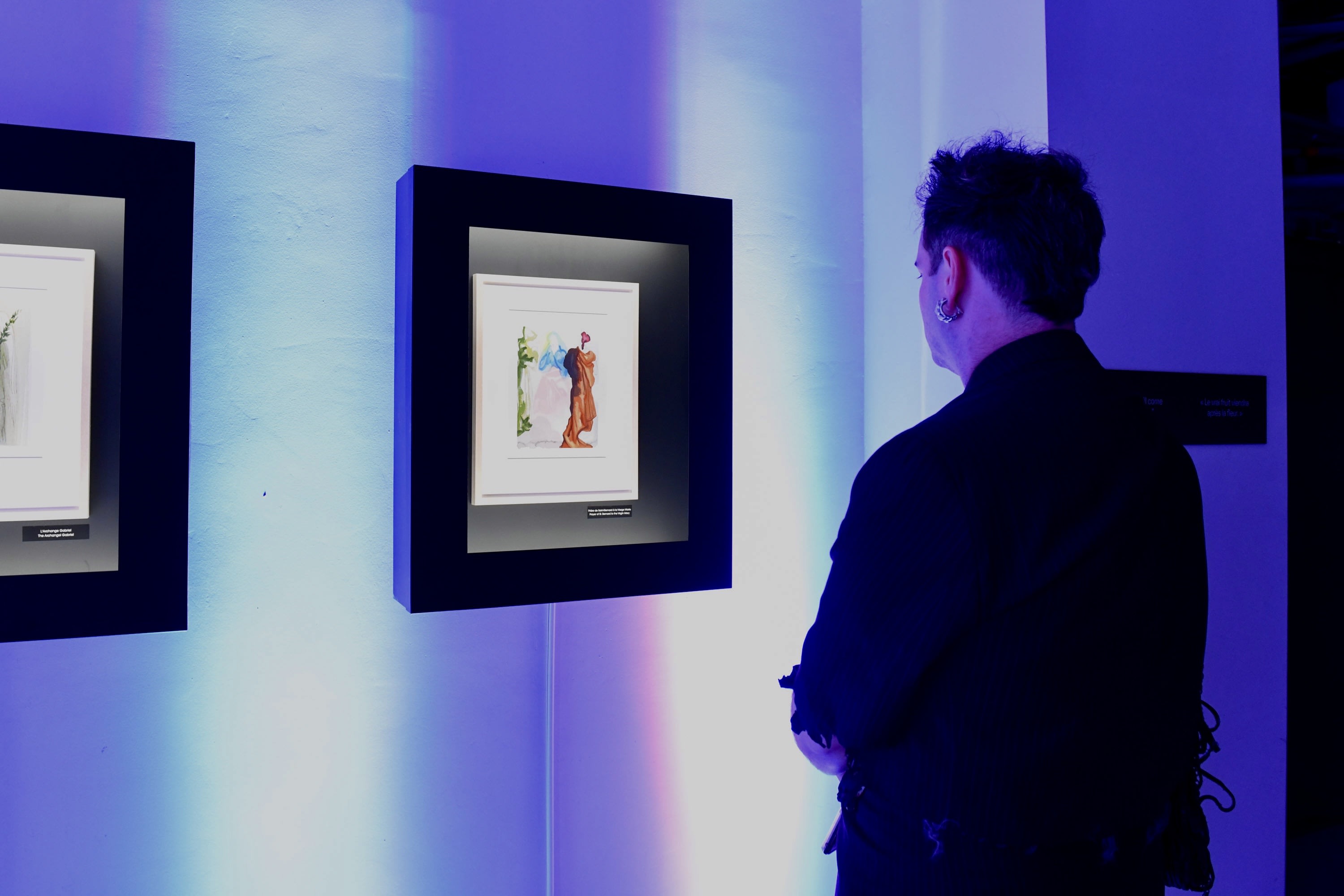 A man looking at artwork on the wall