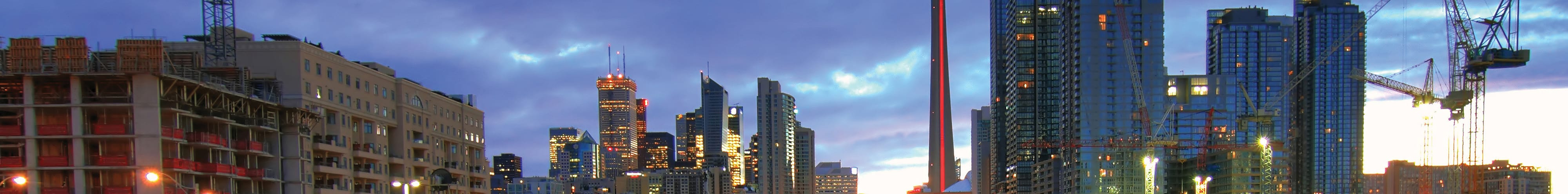 GO Train at dusk in downtown Toronto with CN Tower in the background