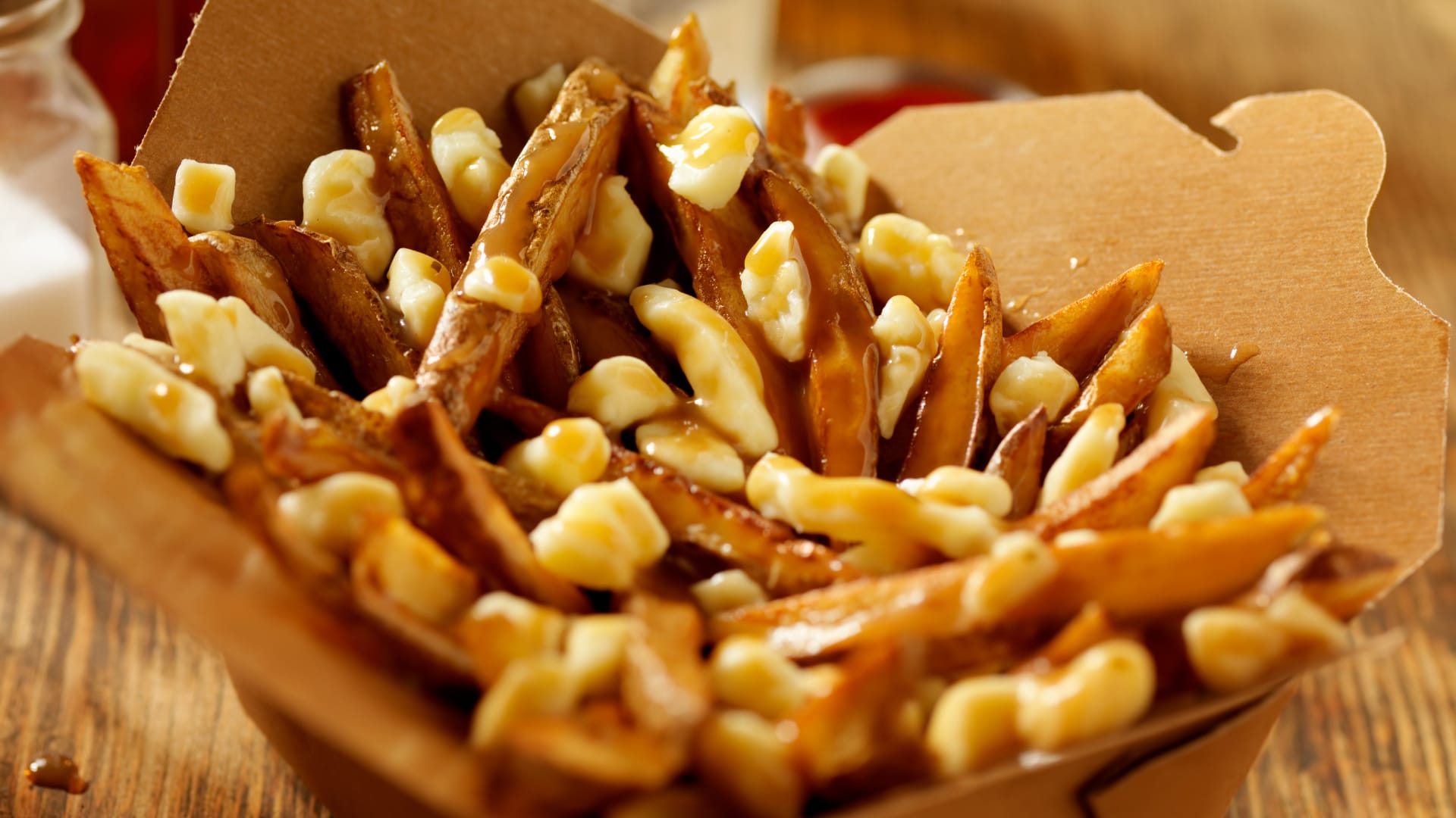 Poutine, fries with gravy and cheese in a paper container