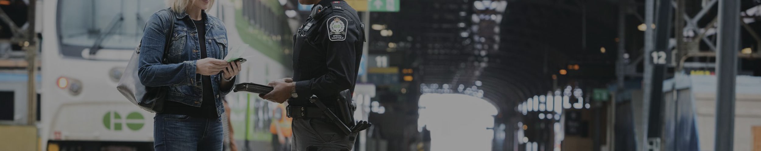 Customer and Customer Protective Officer talking on a train platform.