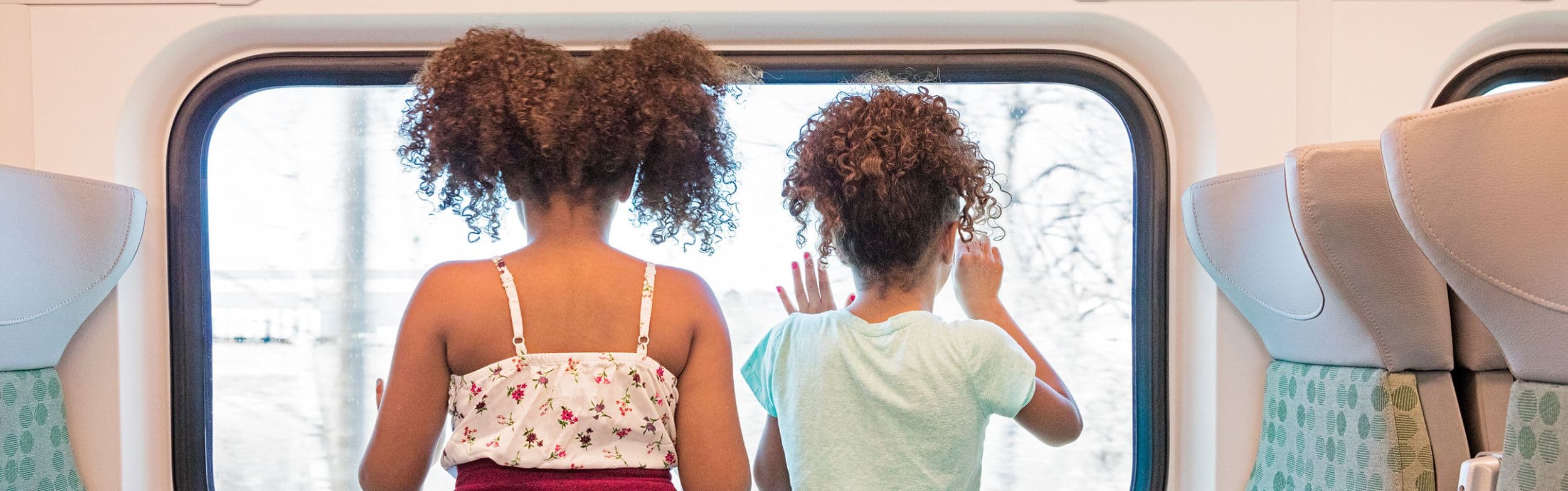 Kids riding on a GO Train looking out of the window
