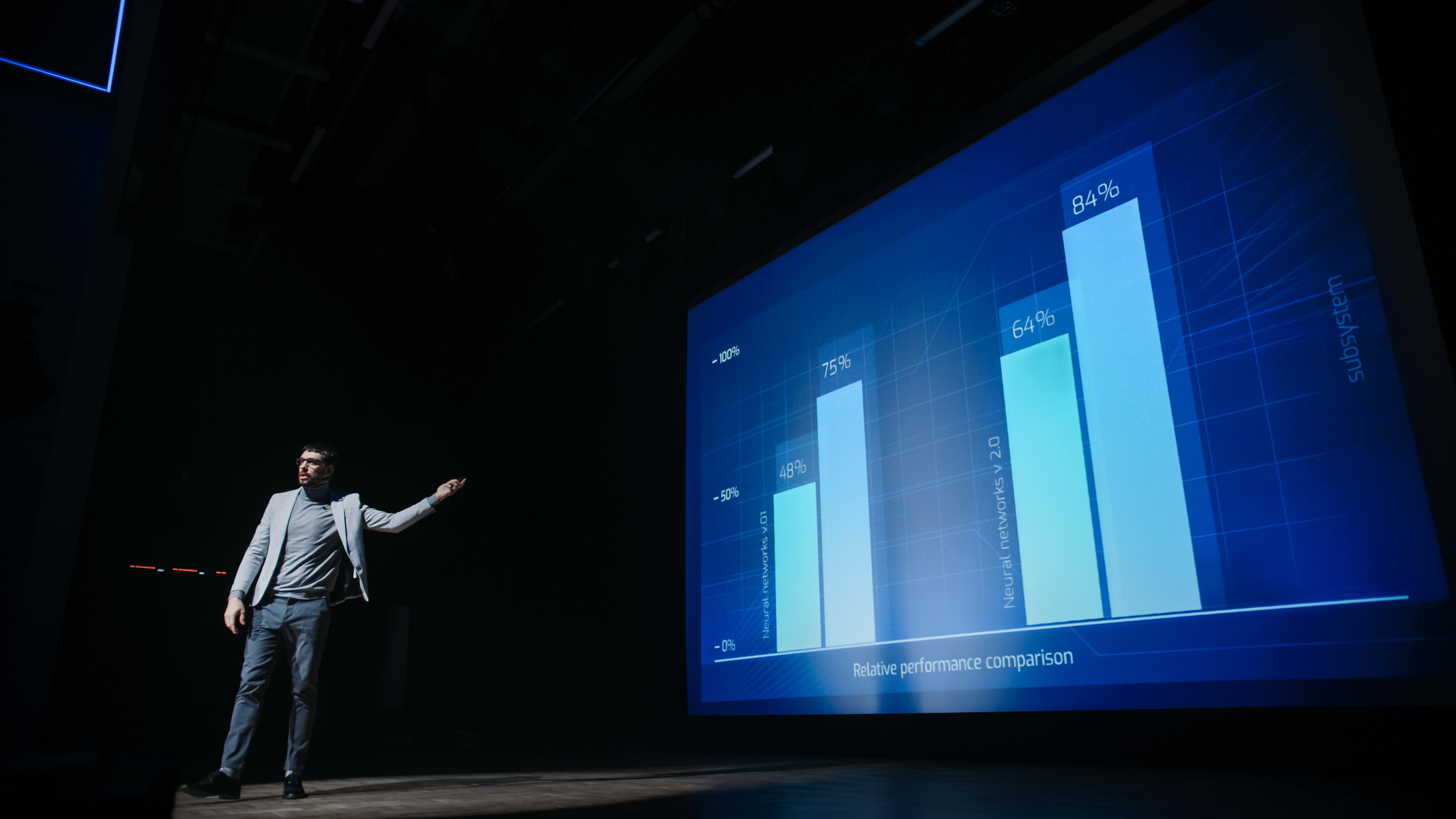 Person standing in front of a large presentation screen at conference