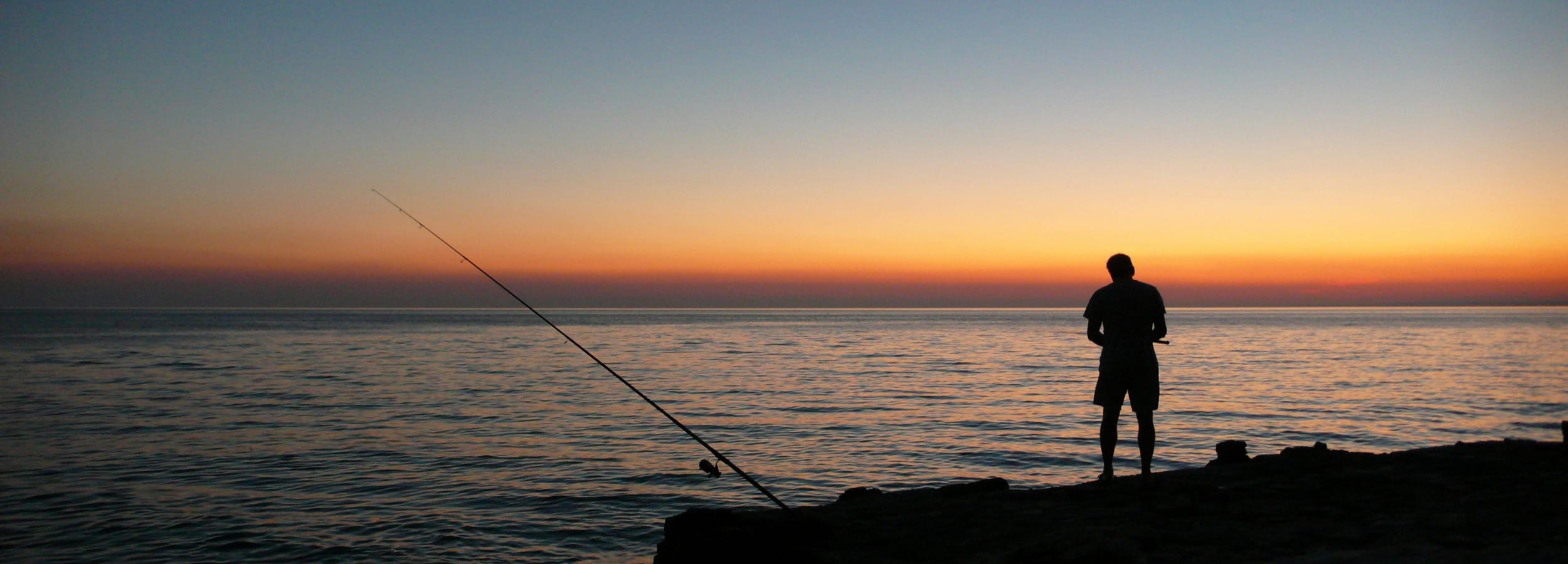 Last glow of sunset while someone is fishing