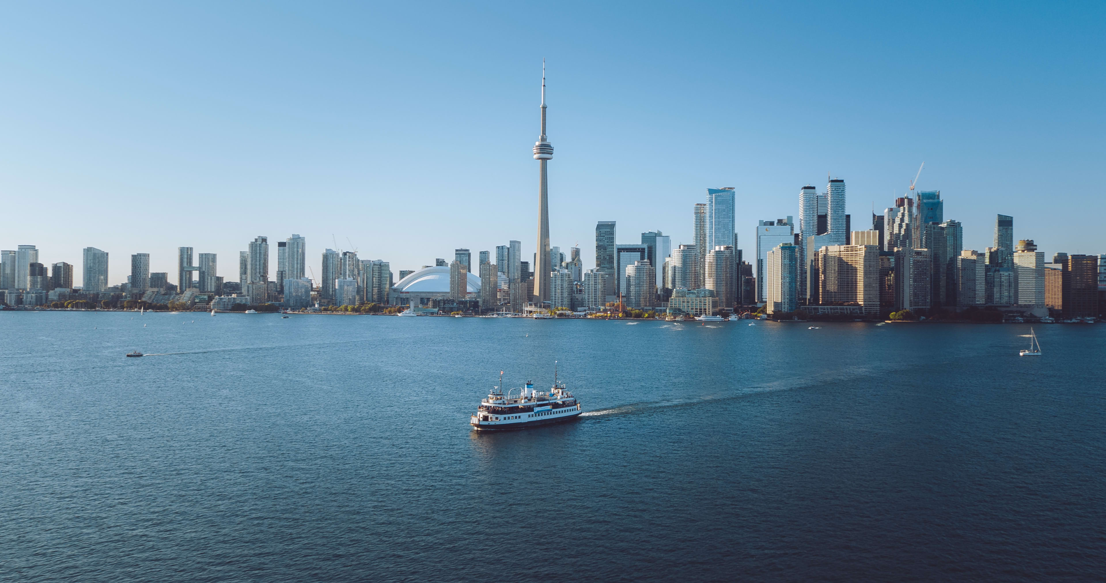 Toronto city skyline overlooking Lake Ontario with ferry in the water