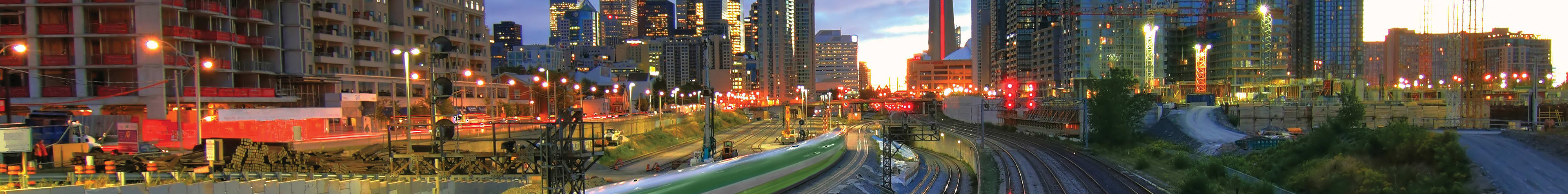 GO Train at dusk in downtown Toronto with CN Tower in the background