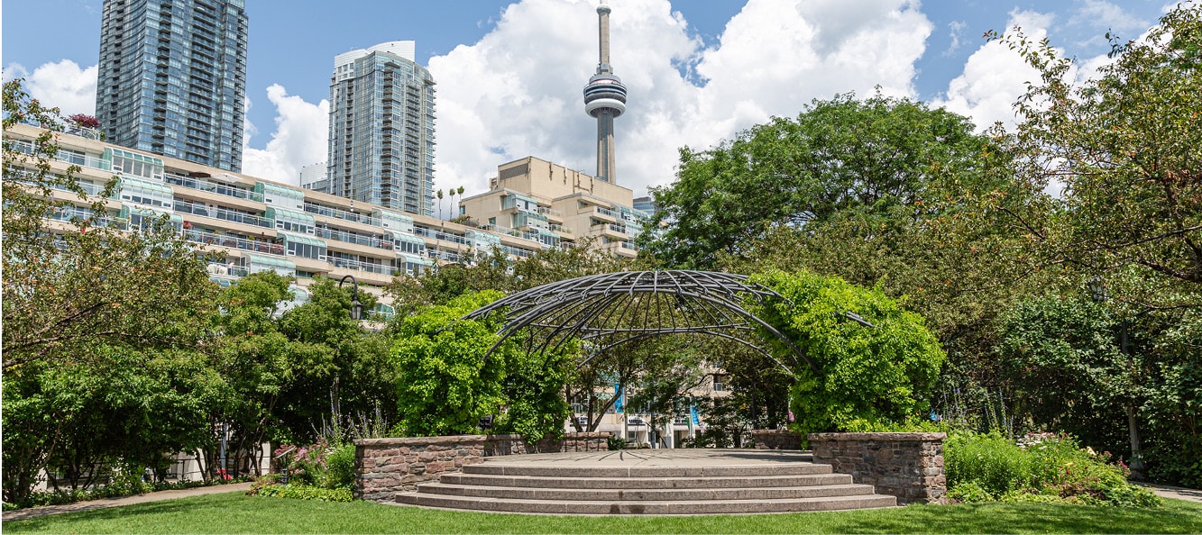 Outdoor garden with trees, clouds and domed structure covered in vines