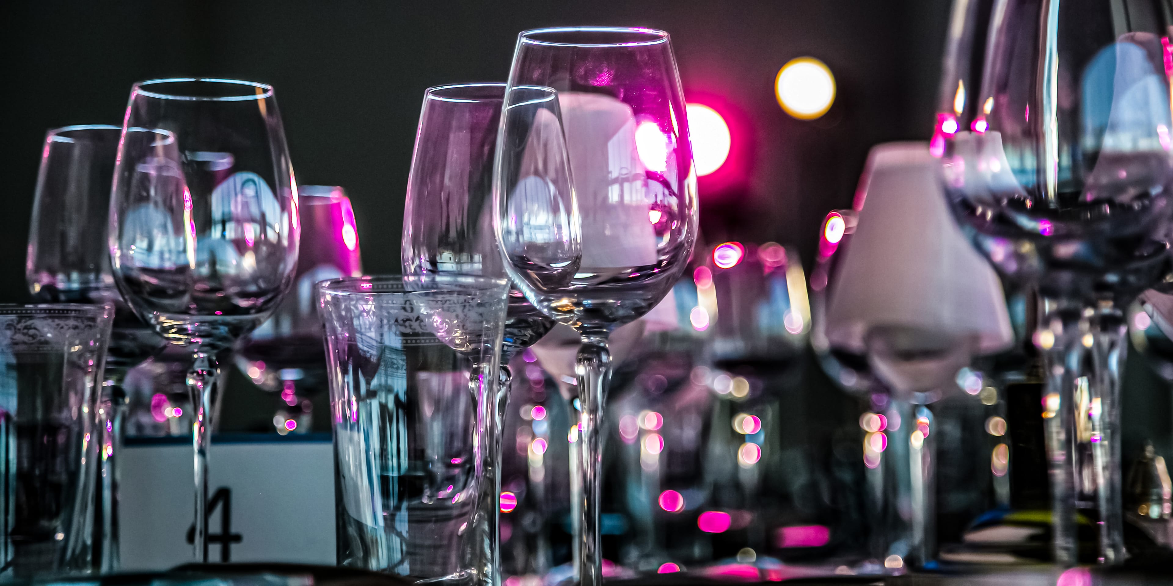 Wine glasses set on a table at a gala.