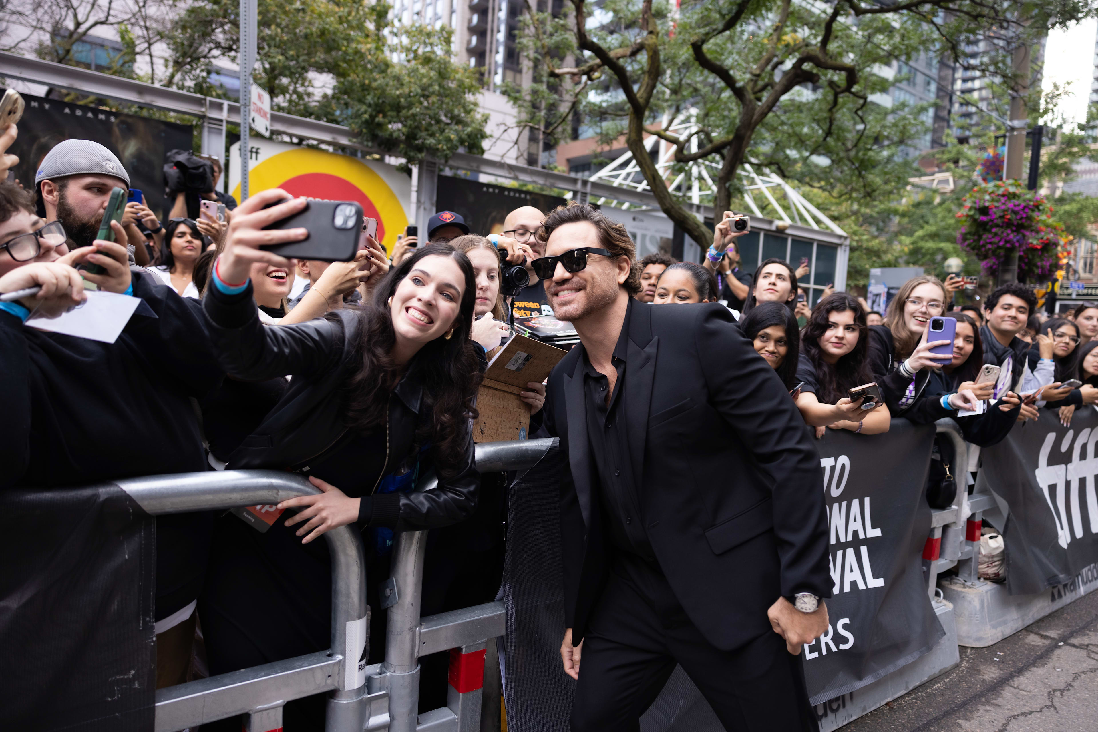 Édgar Ramírez at TIFF taking a selfie photo with a fan.