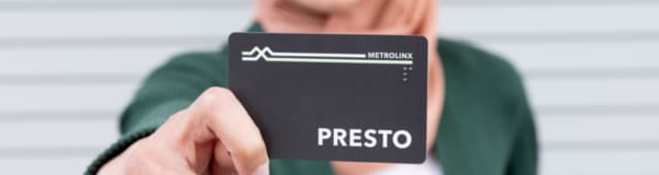 A woman holding a PRESTO card