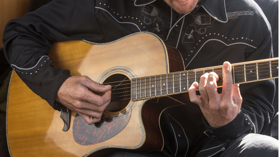 Close up shot of person strumming guitar