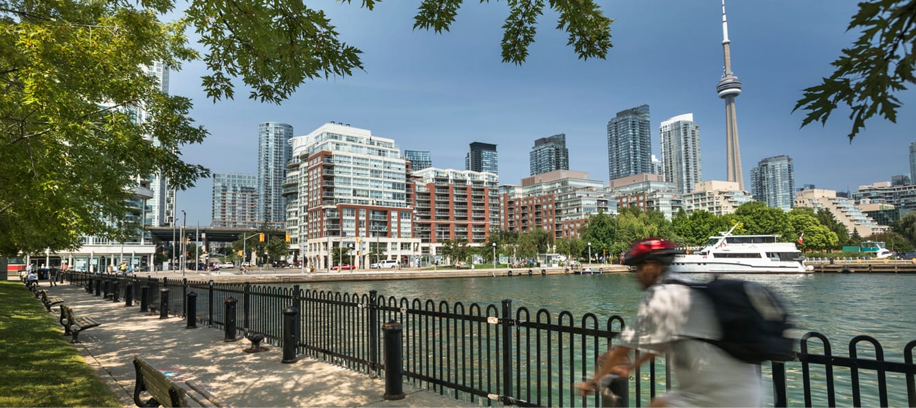 A person riding a bike next to a body of water near Toronto's waterfront