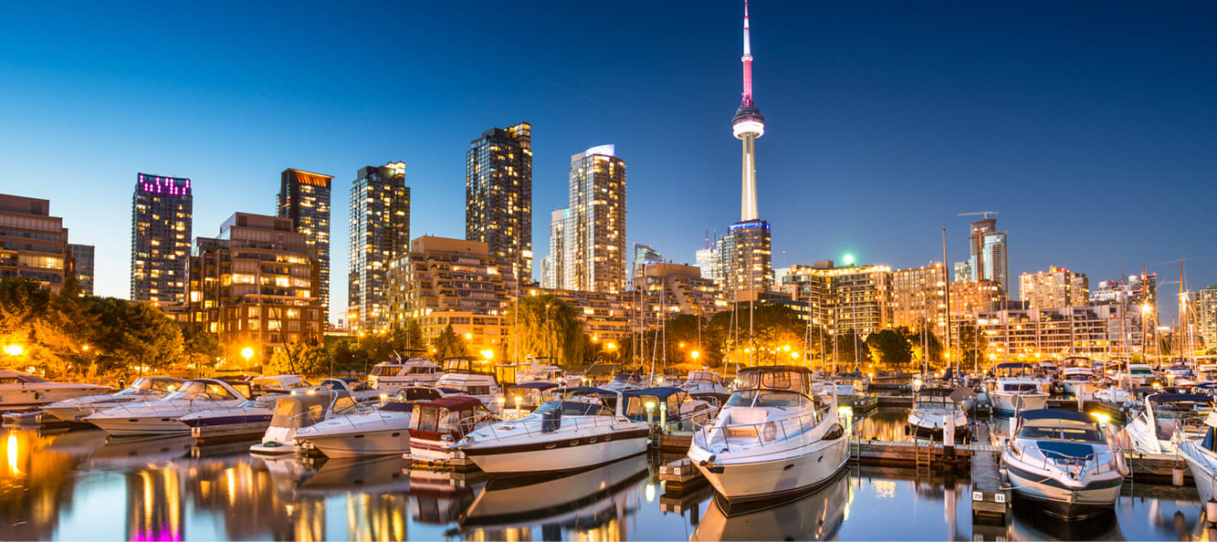 Toronto waterfront with yachts docked in the water and Toronto skyline in the background