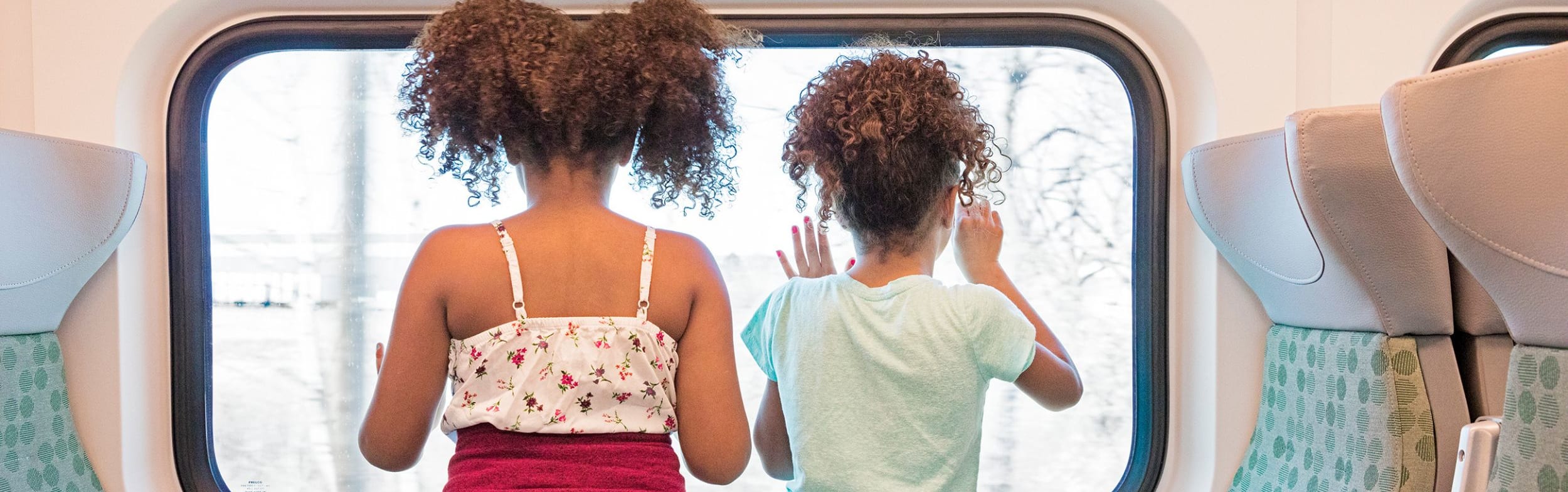Kids riding on a GO Train looking out of the window