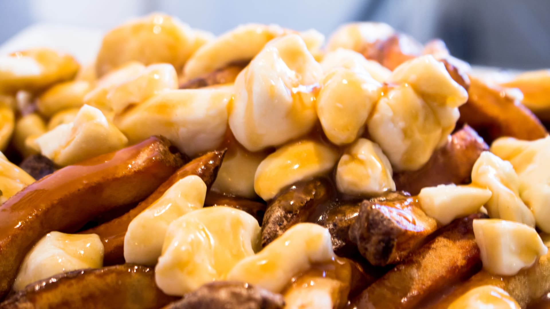 Close up shot of poutine, fries with cheese curds covered in gravy