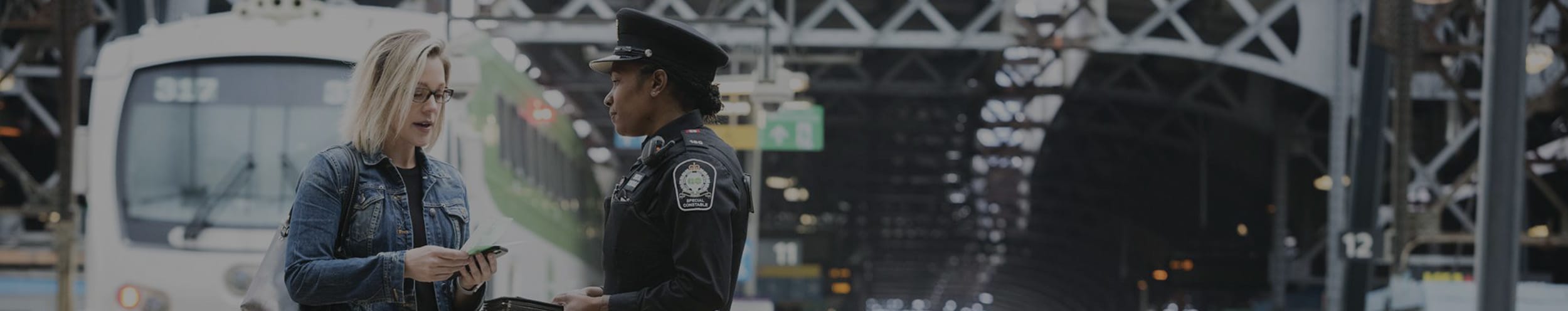 Customer and Customer Protective Officer talking on a train platform.